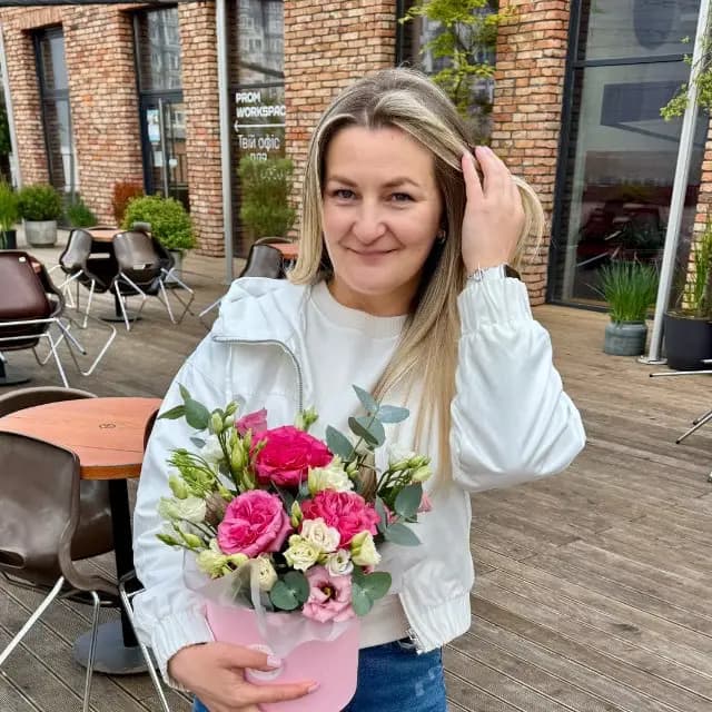 Kateryna Liaskovska holding a bouquet of flowers